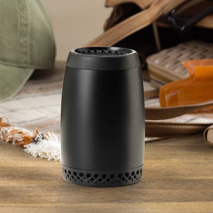 A Scentsy Air Go – Black sits on a table near a Scentsy Pod Twin Pack and a laptop.