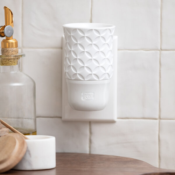 A Scentsy Air Mini – Star is plugged in on a tiled wall.