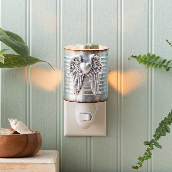 A 15W mini Scentsy Angel Wings Flameless Warmer with rustic galvanized metal and heart-shaped light patterns on a wall.
