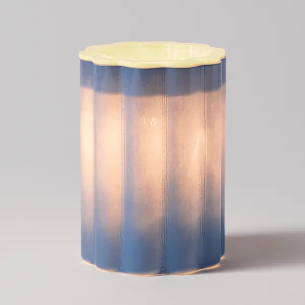 A vibrant ribbed glass Scentsy Bloomie Electric Fragrance Melter glowing with interchangeable colorful contrast dishes.