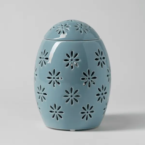 The Scentsy Easter Garden Candle Warmer in an elegant egg shape with glowing floral cutouts across a pastel ceramic shell.