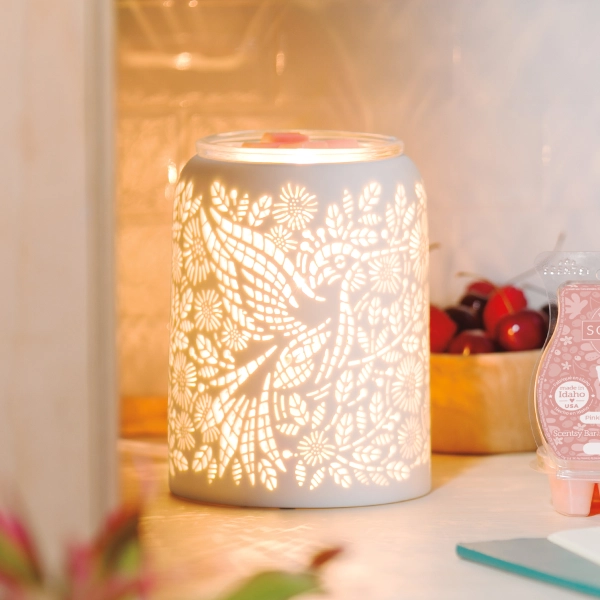 The Scentsy Etched Hummingbird Wax Warmer in white ceramic featuring an illuminated laser-cut bird and floral garden pattern.