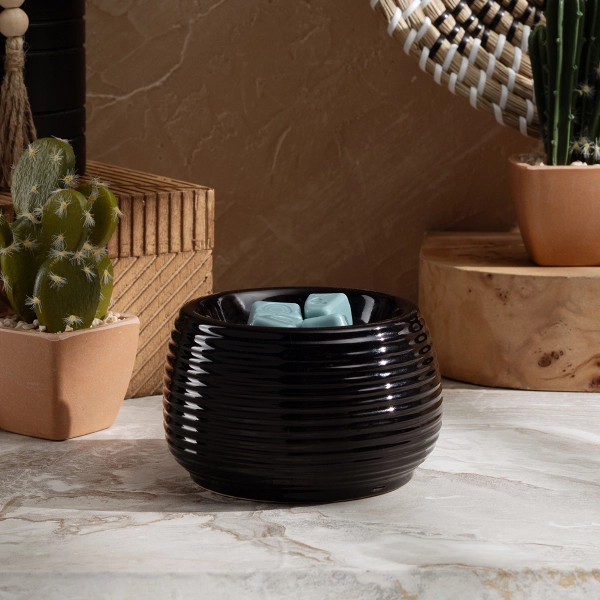 The Scentsy Jet Candle Warmer is a small, ribbed black ceramic dish melting light blue wax.