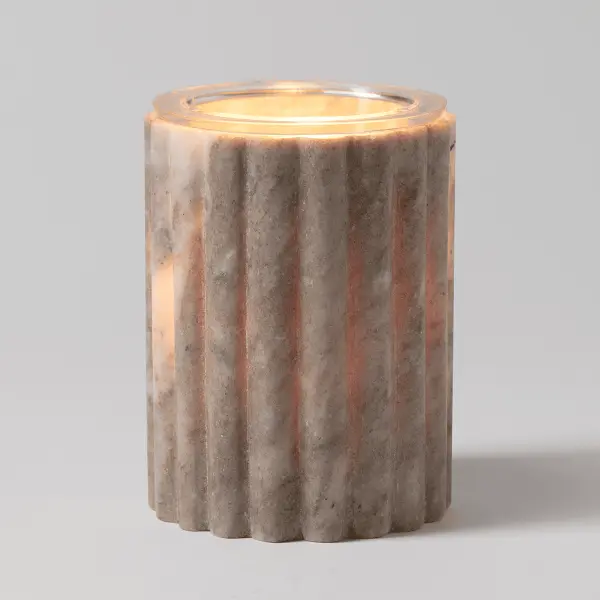 Scentsy Morchana Wax Warmer glowing warmly, showcasing natural veining on a hand-carved fluted marble cylinder.