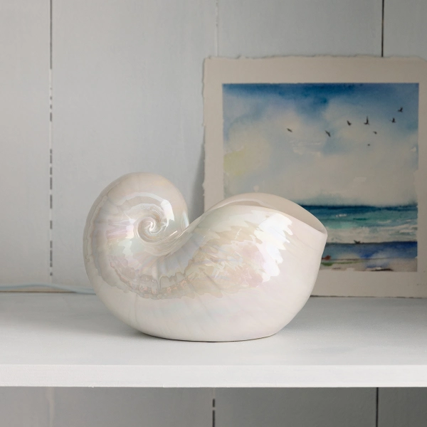 The Scentsy Nautilus Wax Warmer featuring a white ceramic spiraling shell design with an iridescent, pearlescent finish.