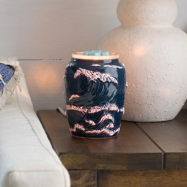 The Scentsy Ocean Crest Electric Fragrance Melter featuring dark navy blue ceramic with deeply sculpted, glowing wave crests.