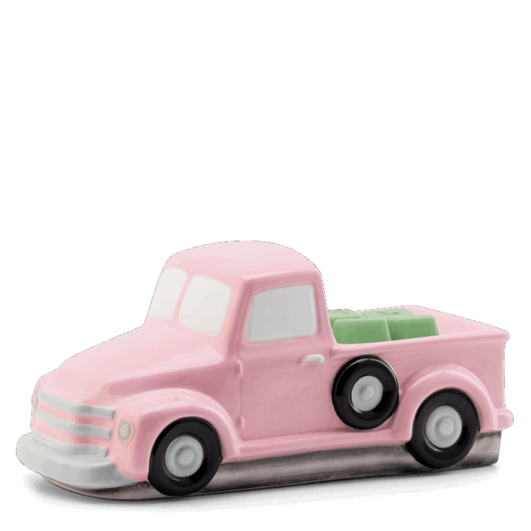 Scentsy Retro Pink Truck Wax Warmer sitting on a table, featuring a classic mid-century pickup truck design with hand-painted pink and silver details.