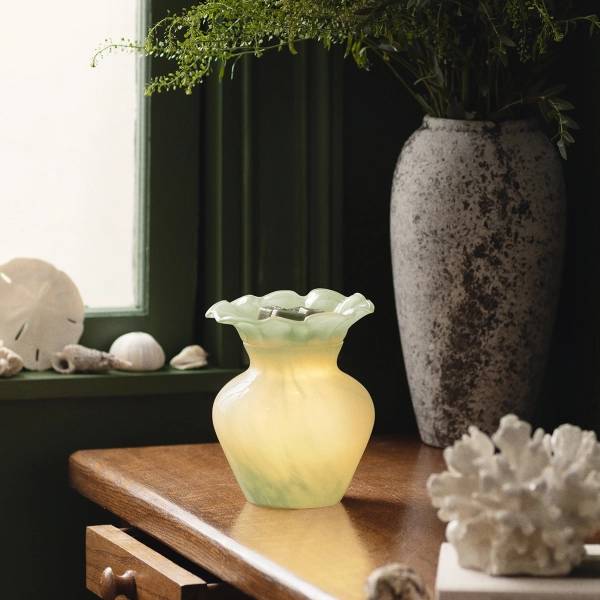 Scentsy Seafoam Bloom Wax Warmer glowing on a wooden table, featuring frosted sea-glass green tones and a ruffled rim.