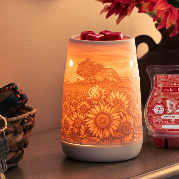 Scentsy Sunflower Fields Wax Warmer glowing with an orange bulb, revealing a detailed 3D lithophane country farm and flower scene.