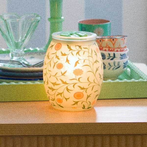 The Scentsy Sunny Vines Electric Fragrance Melter features yellow flowers and winding green leaves on frosted glowing glass.