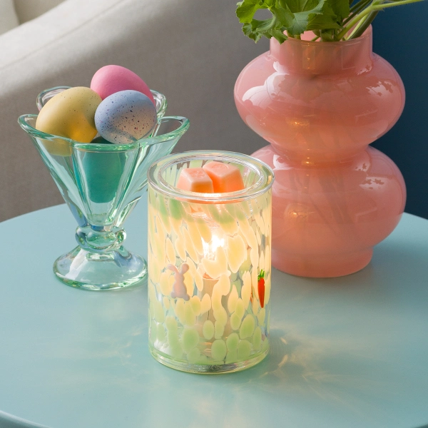 The Scentsy Verdant Escape Electric Fragrance Melter glowing with green confetti glass, a tiny bunny, and a carrot decal.
